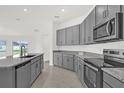 Well-equipped kitchen featuring gray cabinets, granite countertops, and stainless steel appliances at 5736 Thalia Rd, Lakeland, FL 33810