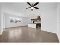 Open-concept living space flows into a kitchen with an island, pendant lighting and modern ceiling fan at 8626 Caribbean Pine Way, Lakeland, FL 33809