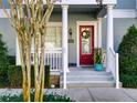 Inviting front entrance with red door, white columns, and landscaping at 535 Crimson Ln, Winter Springs, FL 32708