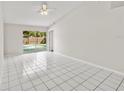 Spacious living room with tile floors, ceiling fan, and sliding glass doors leading to a pool at 5418 S Bracken Ct, Winter Park, FL 32792