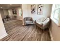 Bright living room with two armchairs and wood-look flooring at 620 Oak St, Auburndale, FL 33823