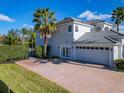 Spacious three-car garage and brick driveway complement the exterior of this home, surrounded by lush landscaping at 10542 Wittenberg Way, Orlando, FL 32832