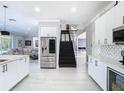 Modern kitchen with stainless steel appliances, white cabinetry, and an open floor plan at 10542 Wittenberg Way, Orlando, FL 32832