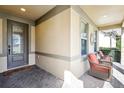 Cozy front porch featuring two chairs, a decorative wreath, and a beautifully designed front door at 14132 Murcott Blossom Blvd, Winter Garden, FL 34787
