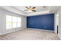 Spacious bedroom with a tray ceiling, new carpet, a large window and freshly painted accent wall at 4245 Arlington Ridge Blvd, Leesburg, FL 34748