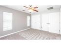 Bright bedroom with a ceiling fan, new carpet, two windows with blinds and two closets at 4245 Arlington Ridge Blvd, Leesburg, FL 34748