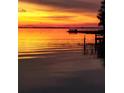 Stunning sunset over calm lake water with a dock at 2256 W County Road 44, Eustis, FL 32726