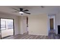 Bright living room with ceiling fan, light grey wood floors, and open access to kitchen and backyard at 261 Dublin Dr, Lake Mary, FL 32746