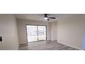 Bright living room with light grey wood floors, ceiling fan, and sliding glass door to the outdoor patio at 261 Dublin Dr, Lake Mary, FL 32746