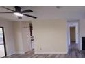 Bright living room with ceiling fan, light grey wood floors, and open access to kitchen at 261 Dublin Dr, Lake Mary, FL 32746
