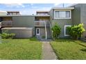 Inviting townhome with lush green grass, mature landscaping, and a quaint front porch with stairs at 5783 Peregrine Ave # C07, Orlando, FL 32819