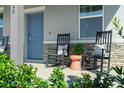 Inviting front porch featuring two rocking chairs and a stylish side table at 344 Belmond Dr, Debary, FL 32713