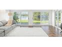 Bright living room with plush carpeting and large sliding glass doors with serene views at 8984 Houston Pl # 103, Orlando, FL 32819