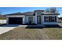 Charming single Gathering home showcasing dark trim and a modern front door, with new landscaping at 6208 Sw 129Th St, Ocala, FL 34473