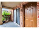 Charming condo entryway featuring a brick facade, a large sliding window, a private door, and lush landscaping at 476 Banyon Tree Cir # 104, Maitland, FL 32751