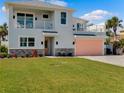 Two-story house with balcony, coral garage door, and lush green lawn at 4260 S Atlantic Ave, Port Orange, FL 32127