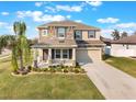 Charming two-story home with stone accents, front porch, manicured lawn, and a two-car garage at 2563 Lamar Valley St, Apopka, FL 32703