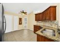 Eat-in kitchen featuring granite countertops, stainless sink, tile flooring and lots of cabinet storage at 2204 Clementine Trl, Clermont, FL 34714