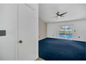 Bright living room boasts blue carpet, ceiling fan, and sliding glass doors to the pool at 2204 Clementine Trl, Clermont, FL 34714