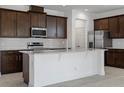 Modern kitchen features dark wood cabinets, granite countertops, and stainless steel appliances at 7247 Rolling Leaf Rd, Groveland, FL 34736