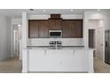 Bright kitchen boasts a large island, stainless steel appliances, and subway tile backsplash at 7247 Rolling Leaf Rd, Groveland, FL 34736