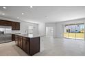 Open concept kitchen and living area with stainless steel appliances and sliding glass door at 7247 Rolling Leaf Rd, Groveland, FL 34736