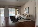 Bright living room with hardwood floors, a modern sofa, and access to the pool area at 1833 Queen Palm Dr, Apopka, FL 32712
