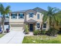 Charming two-story home featuring manicured landscaping and a welcoming front entrance at 1911 Betsy Ross Ln, St Cloud, FL 34769