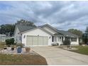 Exterior view of a single Gathering home with an attached two-car garage, and landscaping at 5919 Mcenroe Ct, Leesburg, FL 34748