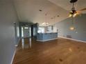 Open living space with hardwood floors and an adjacent kitchen with an island and modern lighting at 5919 Mcenroe Ct, Leesburg, FL 34748