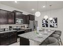 Modern kitchen boasts granite countertops, stainless steel appliances, and pendant lighting at 3955 Lana Ave, Davenport, FL 33897