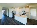 Modern kitchen features white cabinets, stainless steel appliances, and a central island with a sink at 314 Rover Rd, Ormond Beach, FL 32174