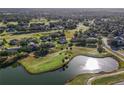 Community overview showing houses near a golf course and pond at 36711 Alaqua Ct, Eustis, FL 32736