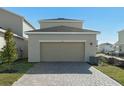 Attached garage with light beige door and brick paver driveway at 438 Belmond Dr, Debary, FL 32713