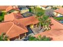 Aerial view of the villa's tile roof, and screened-in patio, surrounded by mature landscaping at 4916 Fiji Cir # 11, Orlando, FL 32808