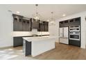 Modern kitchen featuring an island, stainless steel appliances, ample cabinetry, and quartz countertops at 259 Severn Way # 38, Orlando, FL 32803