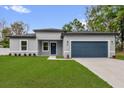 Beautiful home showcasing a manicured lawn, blue garage door, and modern exterior at 494 Marion Oaks Trl, Ocala, FL 34473