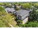 Aerial view of the property with lush landscaping and a beautiful gray tile roof at 8704 Crestgate Cir, Orlando, FL 32819