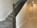 View of the staircase featuring carpeted steps and decorative iron railings at 5274 Teirgarten St, Saint Cloud, FL 34771