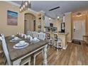 Bright dining area with rustic wood table and modern lighting flowing into kitchen at 912 Charo Pkwy # 223, Davenport, FL 33897