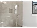 Modern tiled shower with glass enclosure, shower niche, and bright natural light at 1904 Illinois St, Orlando, FL 32803