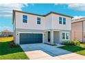 Two-story home featuring a two-car garage, manicured lawn, and modern architecture against a blue sky at 1449 Arbor Hill Dr, Deltona, FL 32725