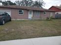 Tan single-story house with a front yard and driveway at 16 N Lancelot Ave, Orlando, FL 32835