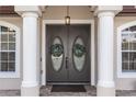 Double front doors with decorative wreaths, columns, and sidelights at 19808 Seaview St, Orlando, FL 32833