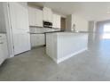 Bright kitchen featuring white cabinets, modern appliances, and a spacious center island at 5292 Teirgarten St, Saint Cloud, FL 34771