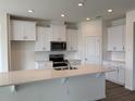 Modern kitchen with stainless steel appliances, white cabinets, and a quartz countertop island at 308 Barebow Ln, Ormond Beach, FL 32174