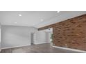 Bright living room with brick accent wall and wood-look floors at 5023 Golf Club Pkwy, Orlando, FL 32808