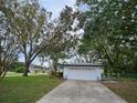 Attached single car garage with white exterior and driveway at 5528 Flamingo Ave, Lakeland, FL 33809