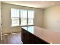 Bright kitchen featuring quartz countertop island, wood floors, and a large window view at 15106 Grove Lake Dr, Winter Garden, FL 34787