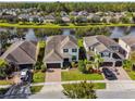 Aerial view of a residential area showcasing houses with well-maintained lawns and a scenic lake backdrop at 1546 Water Elm Ct, Orlando, FL 32825